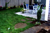 A simple stone walkway connecting steps to a patio