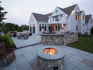 Gas fire pit with outdoor kitchen beyond