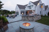 Gas fire pit with outdoor kitchen beyond